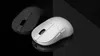 Two computer mice are shown on a reflective black surface. One is white and in the foreground, while the other is gray and in the background. Produktbild-Vorschau