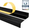 A black stair nosing profile with yellow protective tape being peeled off, and a product quality seal in the upper right corner. Anteprima dell’immagine prodotto