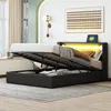 A bedroom scene with a bed that has its storage compartment open, revealing stored items. The bed has LED lighting. Produktbild-Vorschau