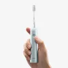 A hand holding a blue electric toothbrush. Produktbild-Vorschau
