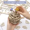Hands assembling a wooden 3D puzzle with colorful crystal spheres. Voir les images du produit