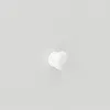 A close-up of a white knob against a textured white background. Náhled obrázku produktu