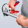 Hands using a pipe cutter to cut a silver pipe. Produktbild-Vorschau