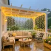 A cozy outdoor patio decorated with string lights, furniture, and plants. Produktbild-Vorschau
