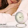 A person sleeping in bed with a pink alarm clock next to them. Produktbild-Vorschau