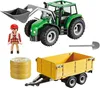 A PLAYMOBIL tractor with a trailer, a farmer figure, hay bales, and a shovel. Voir les images du produit