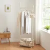 A clothing rack with clothes and a bag is placed next to a small wooden table with books and a mug, near a window with curtains. Produktbild-Vorschau