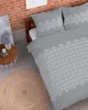 A bedroom scene with a bed, a side table, and a rug. Produktbild-Vorschau