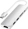 A silver USB-C hub with multiple ports, including HDMI, USB-A, SD card reader, and a USB-C port, connected to a white USB-C cable. Voir les images du produit