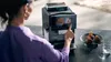 A woman is using a Siemens coffee machine, with pastries and a glass of water on the counter. Produktbild-Vorschau