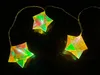 Three star-shaped LED lights on a dark, reflective surface. Produktbild-Vorschau