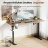 A modern, adjustable standing desk with a computer monitor, lamp, and accessories. Produktbild-Vorschau