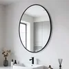 A bathroom vanity with a sink, faucet, and an oval mirror hanging on the wall. Podgląd zdjęcia produktu
