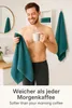 A man in a bathroom holding a towel and a mug of coffee. Produktbild-Vorschau