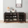 A dark brown shoe cabinet with multiple shelves and doors, filled with shoes and some decorative items on top. Náhľad obrázku produktu