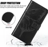 A black flip-style phone case with a butterfly embossed design, shown in a dynamic, angled shot with a cracked ground effect at the bottom. Produktbild-Vorschau