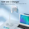A white USB-C charger plugged into a wall socket, with its cable coiled on a desk next to a laptop. Produktbild-Vorschau
