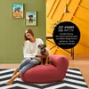 A woman and her dog are sitting on a red beanbag chair in a room with green and yellow walls. Voir les images du produit