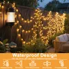 String lights on a wooden fence in the rain, with a wall lamp and plants. Náhled obrázku produktu