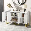 A white sideboard with gold legs and handles, decorated with books, jars, and a lamp. Produktbild-Vorschau