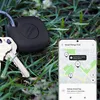 A Samsung Galaxy SmartTag and keys are placed on grass, with a smartphone displaying the SmartThings Find app showing the location of the SmartTag. Náhľad obrázku produktu