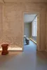 An interior shot showing a doorway leading to a room with a table and stools, illuminated by strip lighting. Produktbild-Vorschau