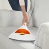 A person is using a handheld vacuum cleaner on a light-colored sofa. Produktbild-Vorschau