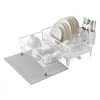 A white wire dish rack filled with various dishes and glasses, placed on a gray mat. The dish rack is positioned at an angle on a white background. Produktbild-Vorschau