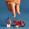 A child's finger is about to touch a Lego stunt bike and a Lego minifigure. Náhled obrázku produktu