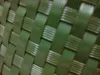 A close-up view of a woven green material, likely a balcony screen or fence covering, showing the texture and pattern of the weave. Produktbild-Vorschau
