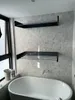 A bathroom with a bathtub and two wall-mounted shelves. Voir les images du produit