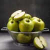 A colander filled with green apples, with two apples cut in half. Anteprima dell’immagine prodotto