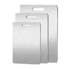 Three stainless steel cutting boards of varying sizes are stacked and displayed against a white background. Produktbild-Vorschau