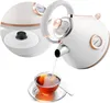A white electric kettle pouring hot water into a glass cup of tea. Produktbild-Vorschau