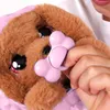 A person is holding a pink bone-shaped toy near a brown plush dog toy. Produktbild-Vorschau