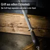 A sharpening steel with a dark wood handle rests on a rough wooden surface. Voir les images du produit
