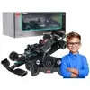 A child is shown next to a toy race car and its packaging. Produktbild-Vorschau