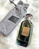A bottle of perfume and its fabric pouch are displayed on a fluffy white surface. Náhľad obrázku produktu