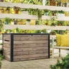 A wooden storage box is placed on a patio with plants on shelves behind it. Produktbild-Vorschau