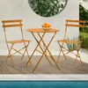 A metal bistro set with two chairs and a table, placed on a wooden deck next to a pool. Produktbild-Vorschau