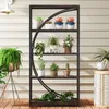 A multi-tiered shelf unit filled with various potted plants, placed on a wooden deck against a light-colored, horizontally paneled wall. Voir les images du produit