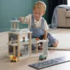 A young boy is playing with a wooden airport toy set on the floor. Voir les images du produit