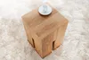 A wooden side table with a cup and saucer on top, placed on a fluffy rug. Produktbild-Vorschau