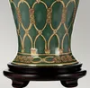 Close-up of the base of a decorative vase with intricate gold detailing on a dark wooden stand. Podgląd zdjęcia produktu