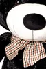Close-up of a large black teddy bear's face, showing its white snout and a checkered bow. Podgląd zdjęcia produktu