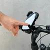 A hand is shown touching a smartphone mounted on a bicycle handlebar. Produktbild-Vorschau