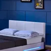 A close-up view of a white LED bed with blue lighting, set against a blue tiled wall. Náhled obrázku produktu