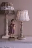 Two lamps and a figurine of a girl holding a doll are displayed on a shelf. Produktbild-Vorschau