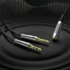 A close-up shot of a Ugreen audio splitter cable with 3.5mm jack connectors, set against a dark, textured background with abstract sound wave graphics. Podgląd zdjęcia produktu