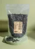 A bag of pumpkin seeds is displayed on a light green surface. Produktbild-Vorschau